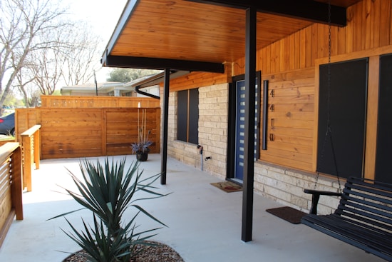 A black bench sitting on the side of a building