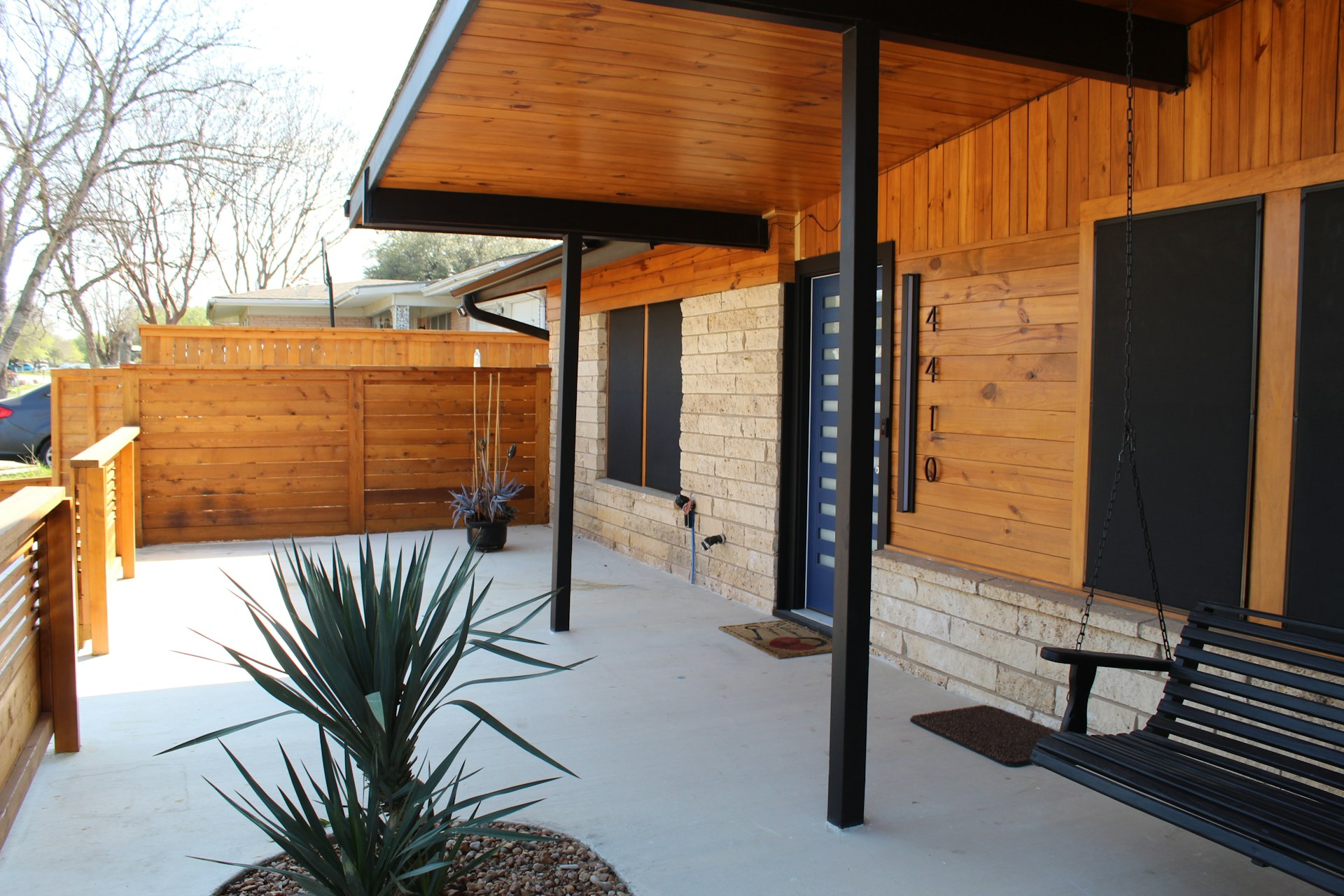 A black bench sitting on the side of a building