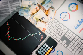 A calculator sitting on top of a pile of money