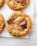 Four chocolate chip cookies on a piece of parchment paper