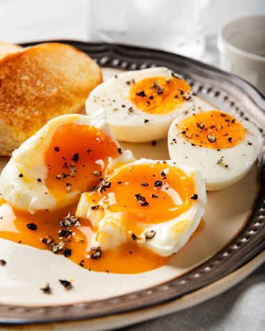 A plate of eggs, toast, and butter on a table