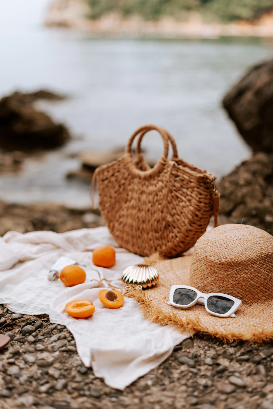 Straw bag styled with a sun hat and sunglasses at the beach