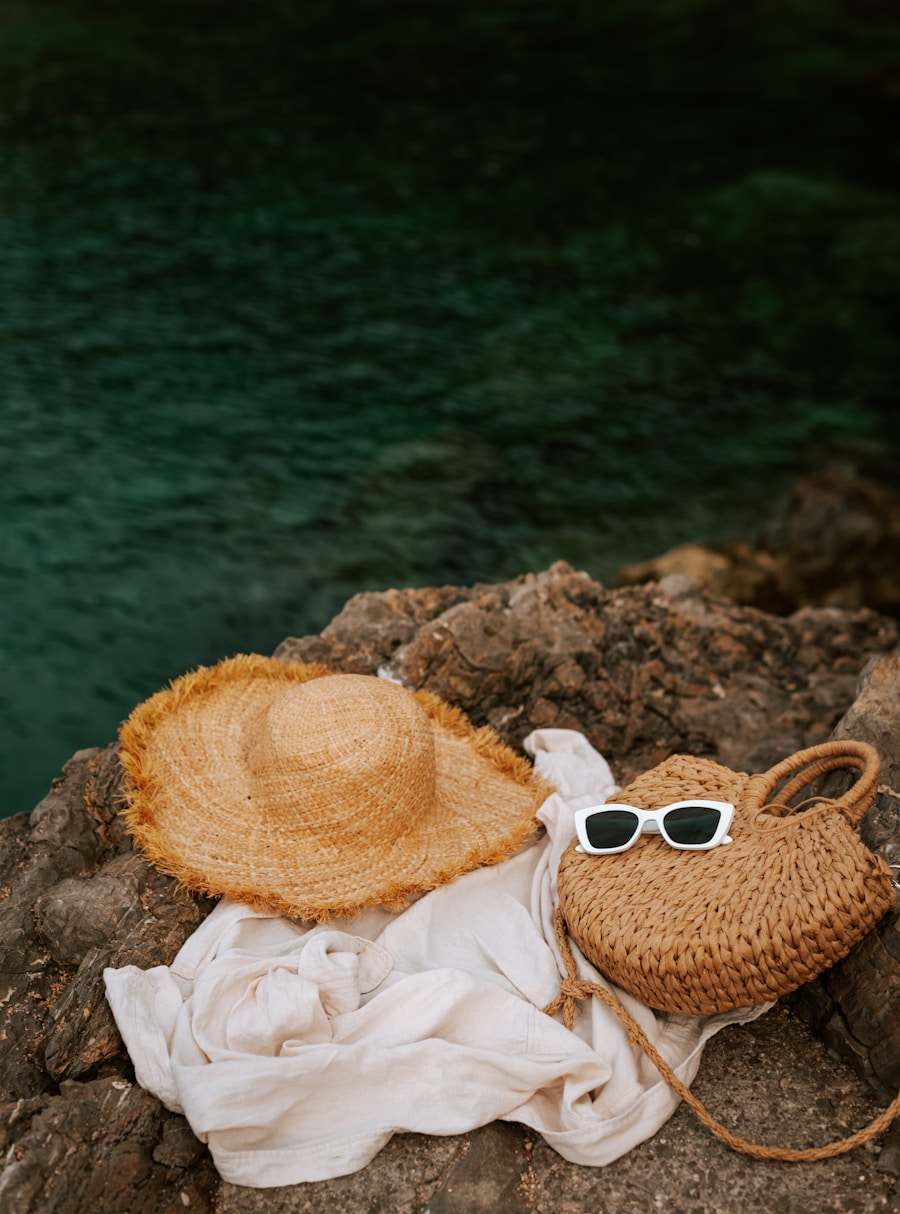 Sombrero de paja y lentes sobre roca junto al mar
