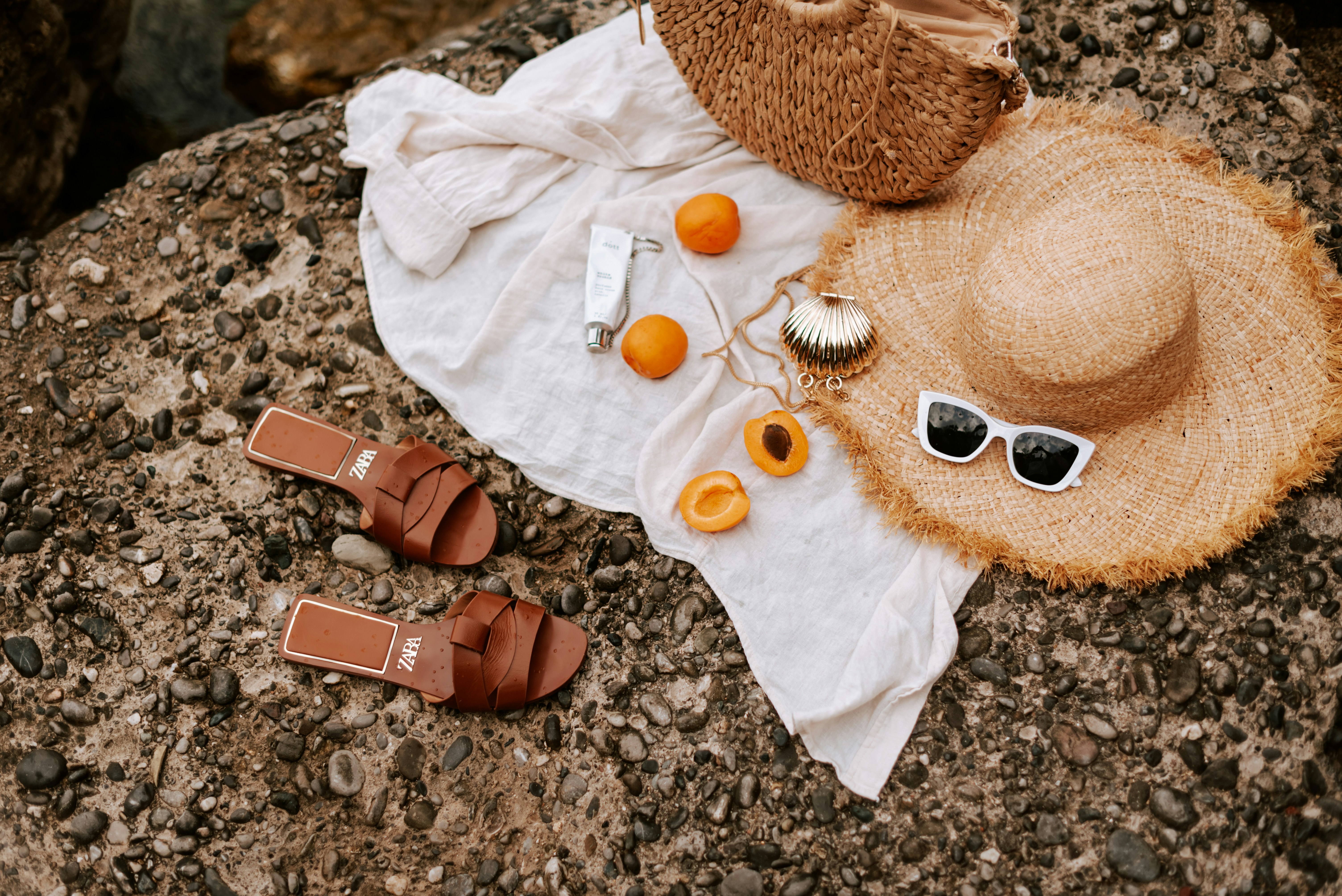 a woman applying sunscreen to her face on a sunny beach