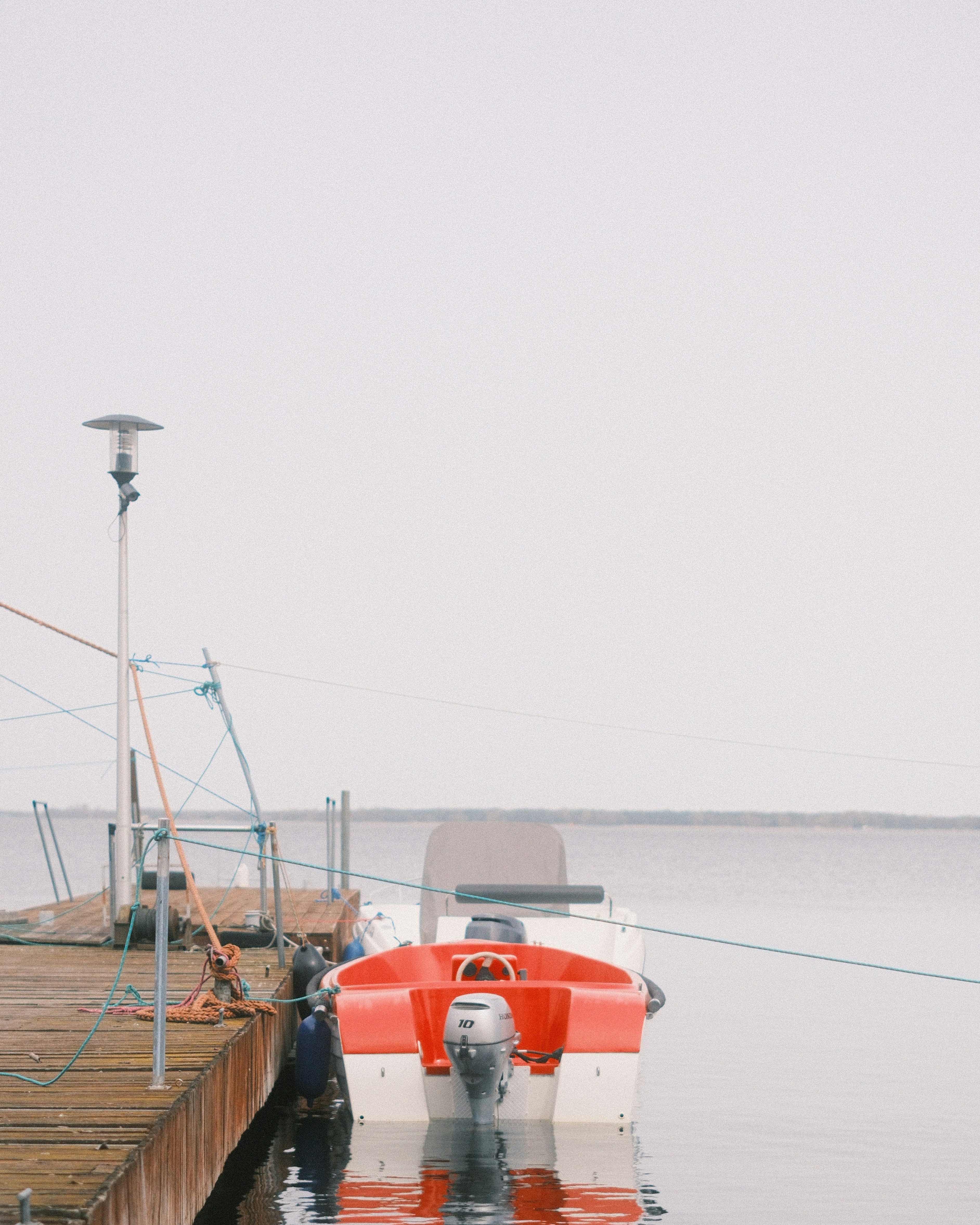 A red and white boat tied to a dock