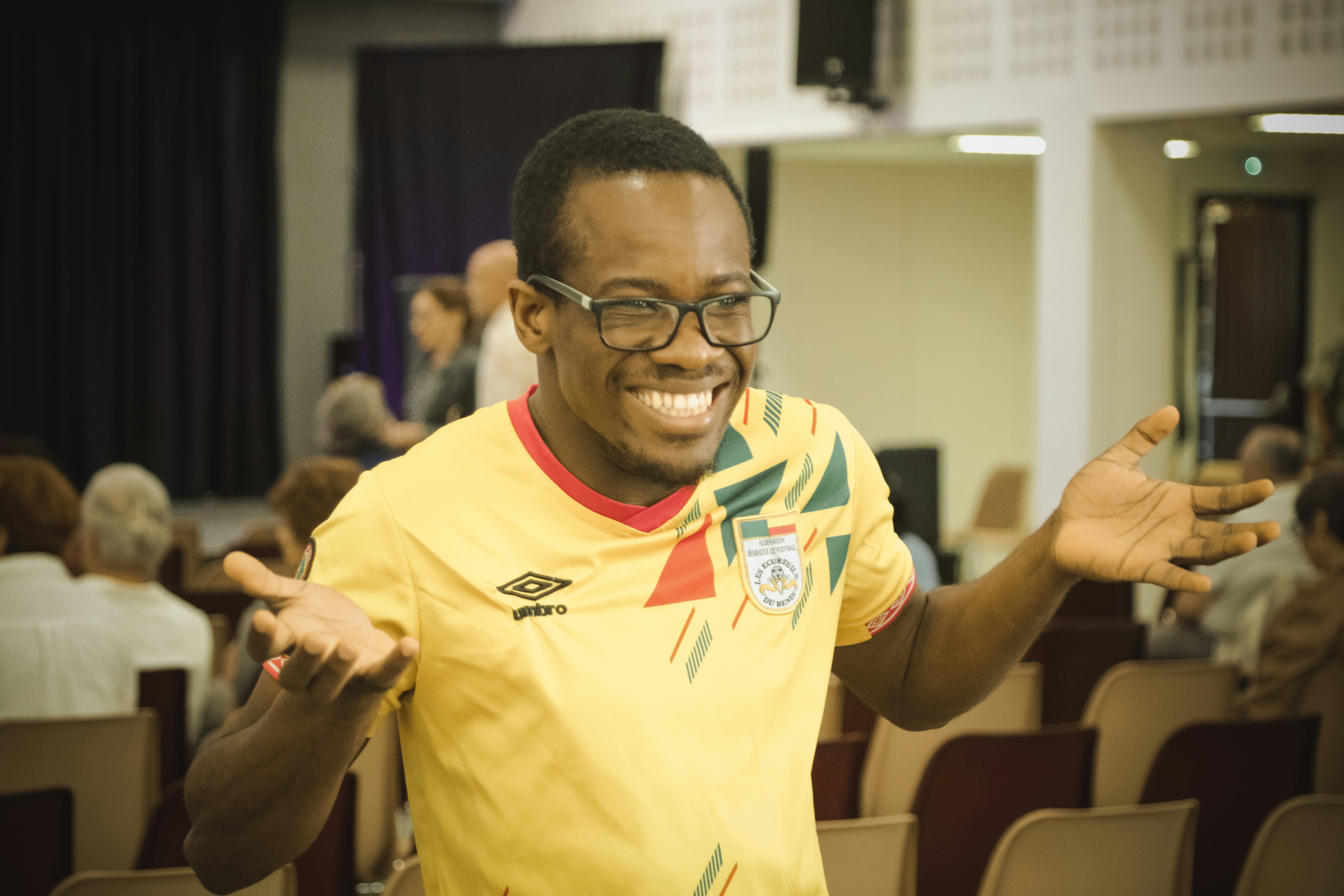 群衆の前に立つ黄色いシャツを着た男