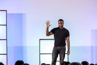 A man standing on a stage with his hands in the air
