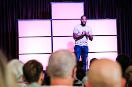 A man standing on top of a stage in front of a crowd