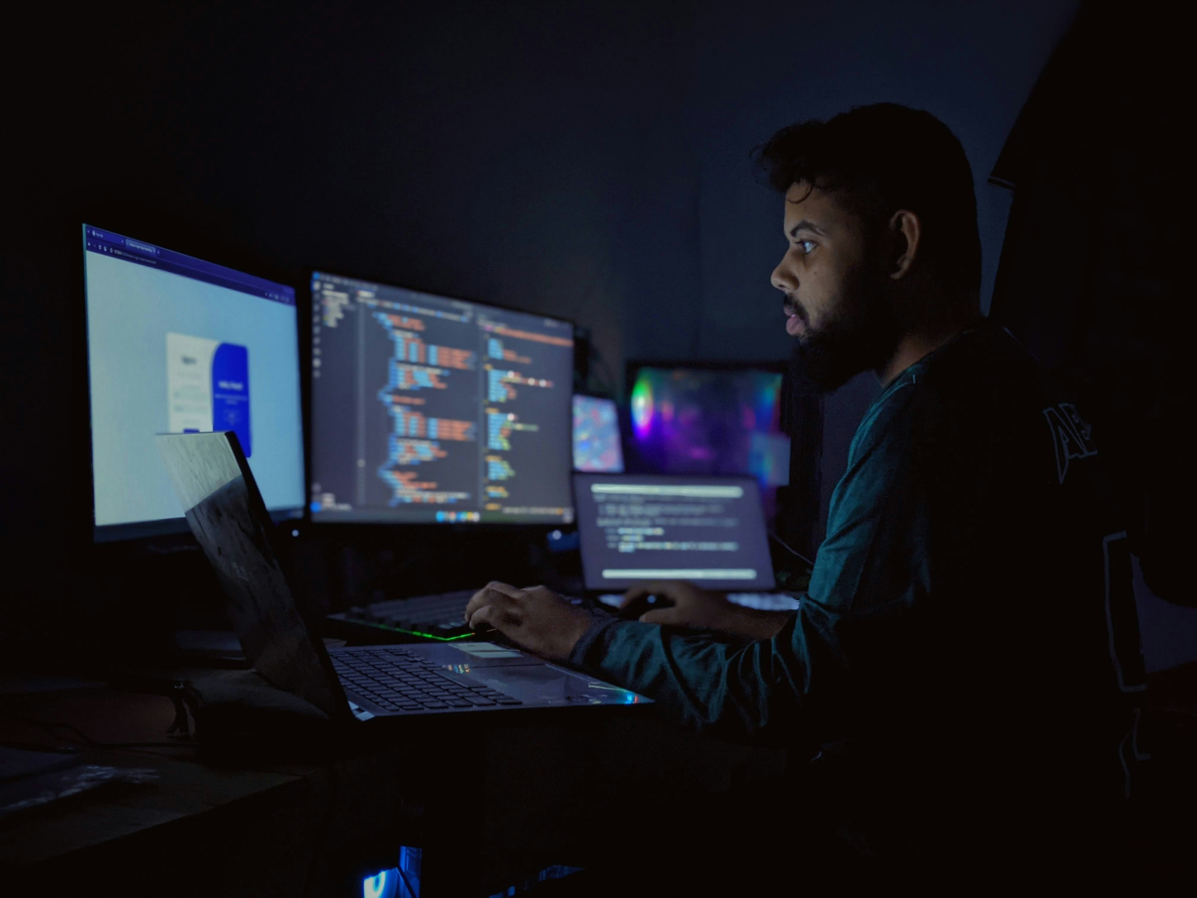 cybersecurity professional looking at complex data on multiple screens