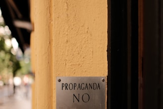 A sign on the side of a building that says propaganda no