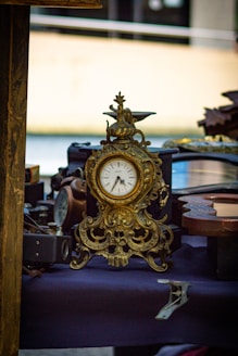 A gold clock sitting on top of a table