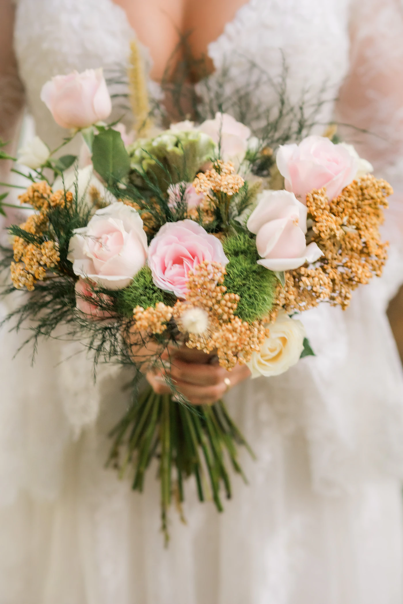 How to make your own bridal bouquet — A finished DIY bridal bouquet with a white ribbon handle resting on a table.