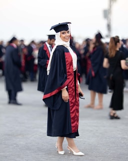 A woman in a graduation gown standing in front of a crowd