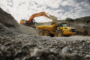 A large yellow truck driving down a dirt road