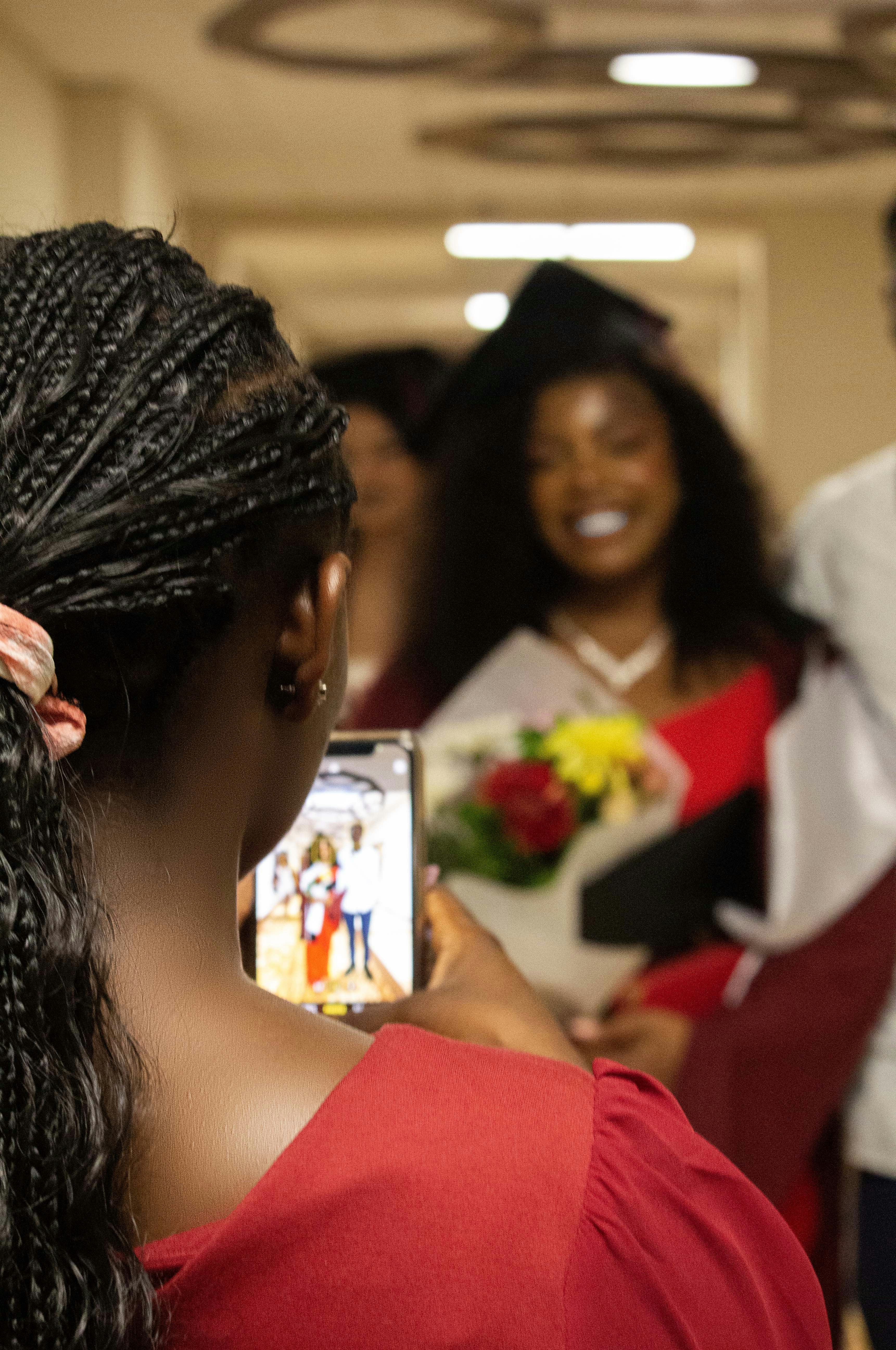 A student in a graduation cap and gown, smiling.