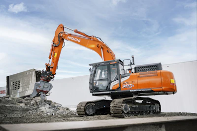 A large orange excavator sitting on top of a pile of dirt