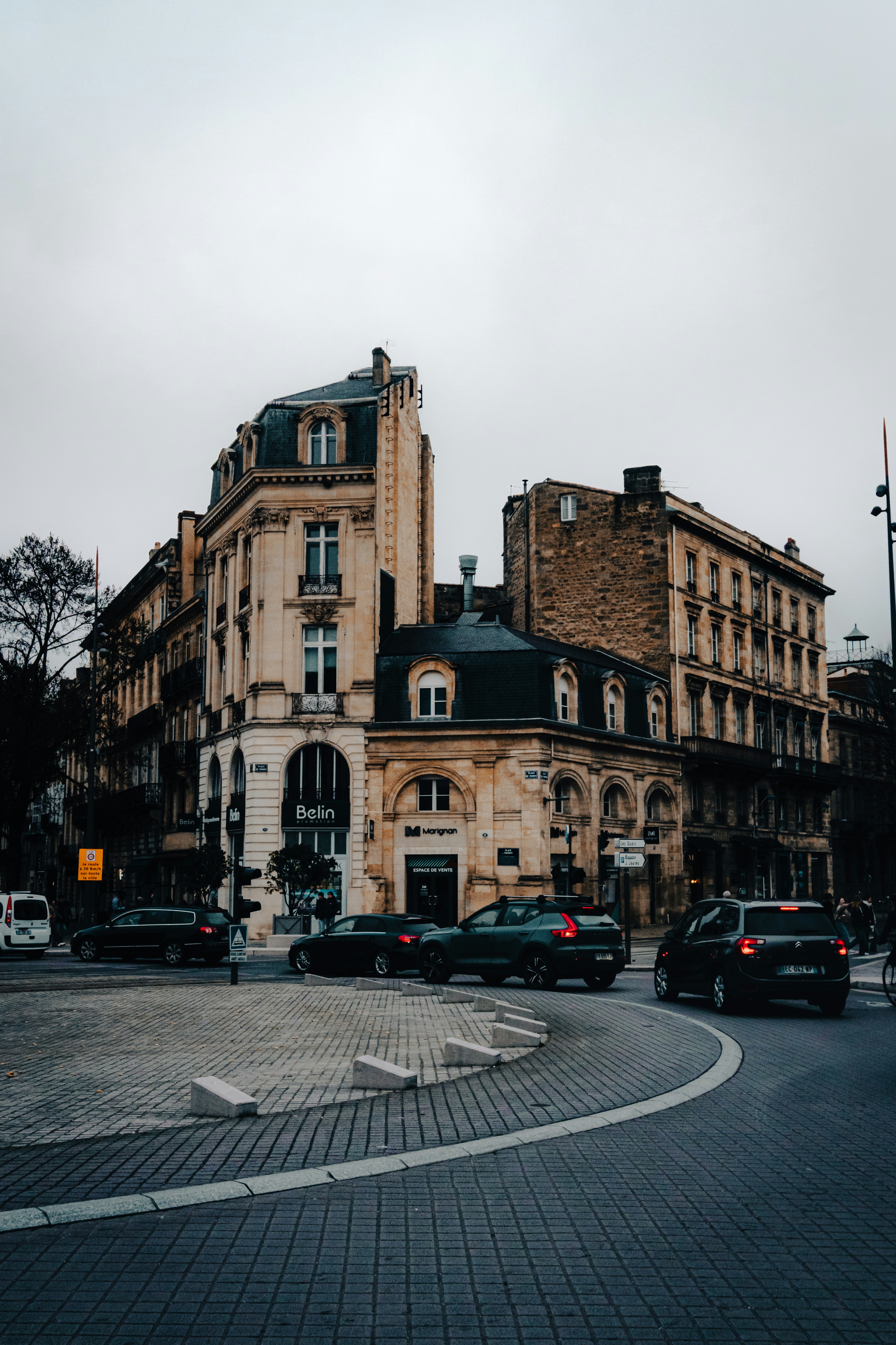A city street filled with lots of traffic next to tall buildings