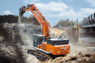 An orange excavator digging dirt in a construction site