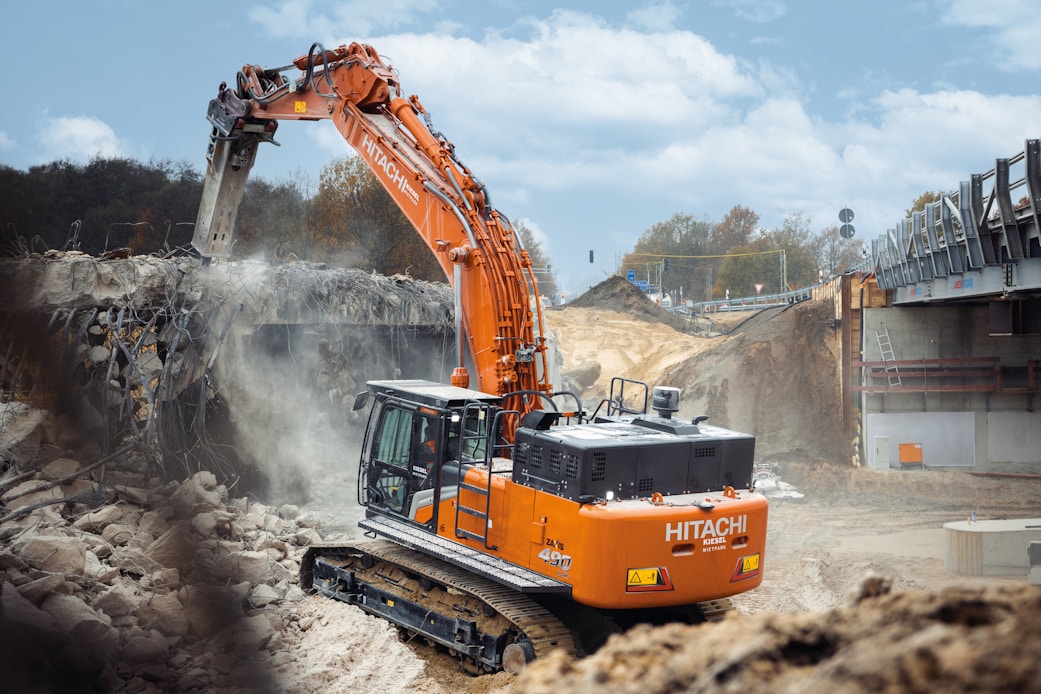 An orange excavator digging dirt in a construction site