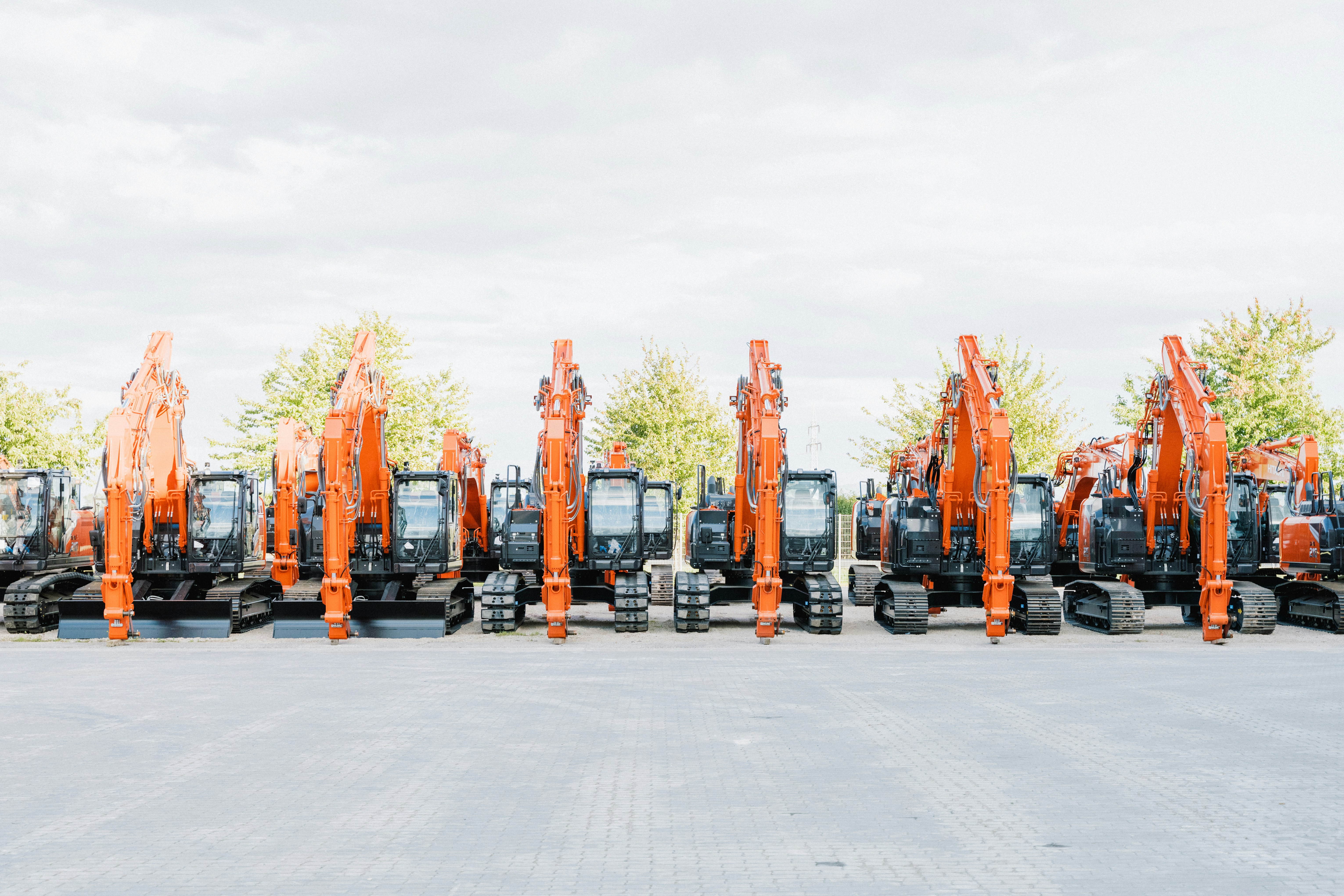 Row of used electric pickup trucks lined up at a dealership, ready for sale