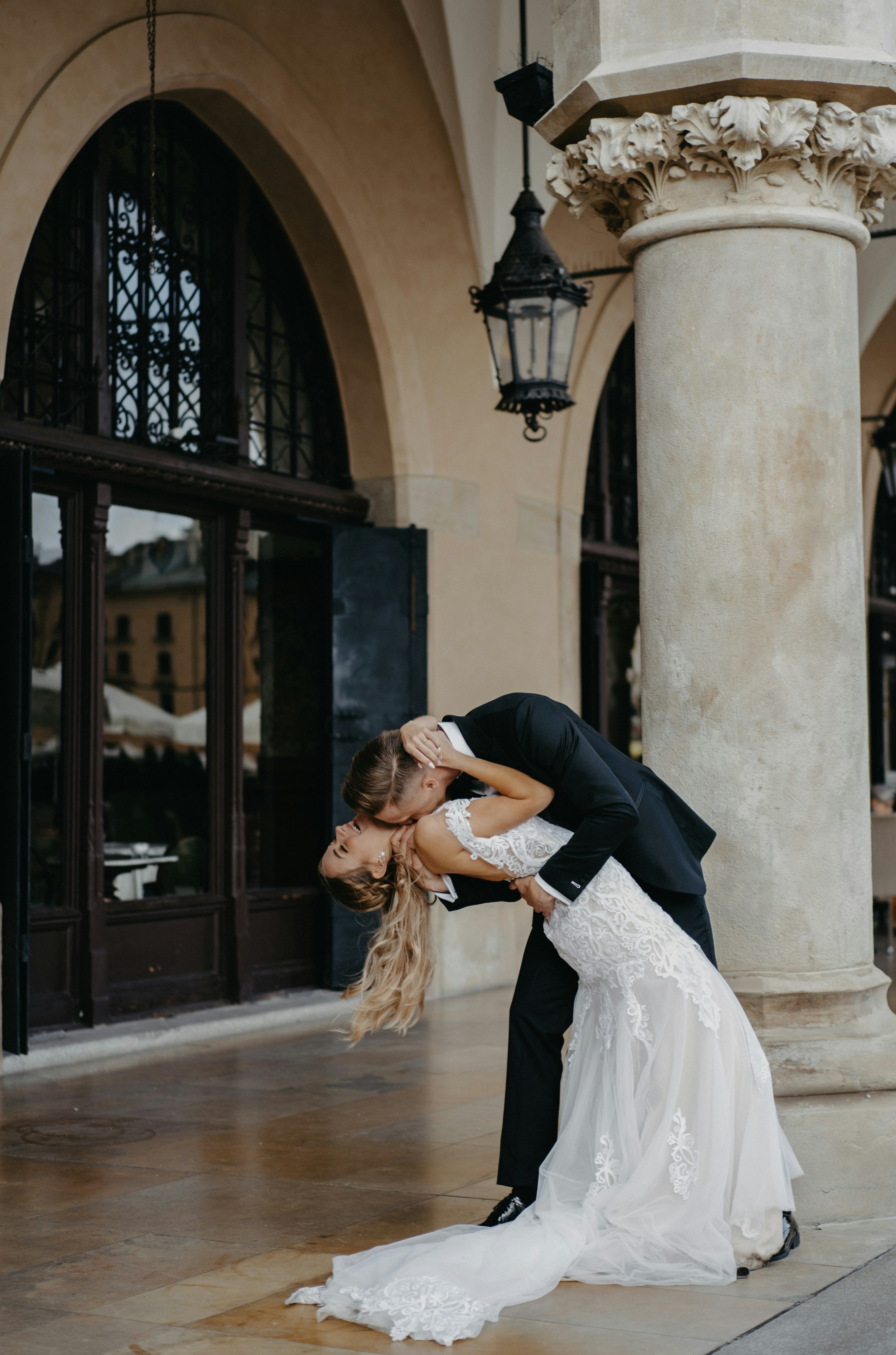 A bride and groom kissing in front of a building