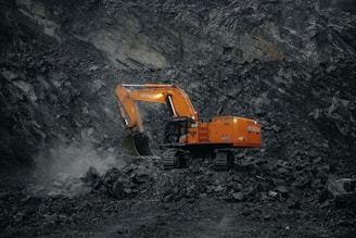 A large orange truck driving down a dirt road