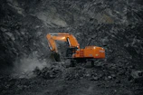 A large orange truck driving down a dirt road