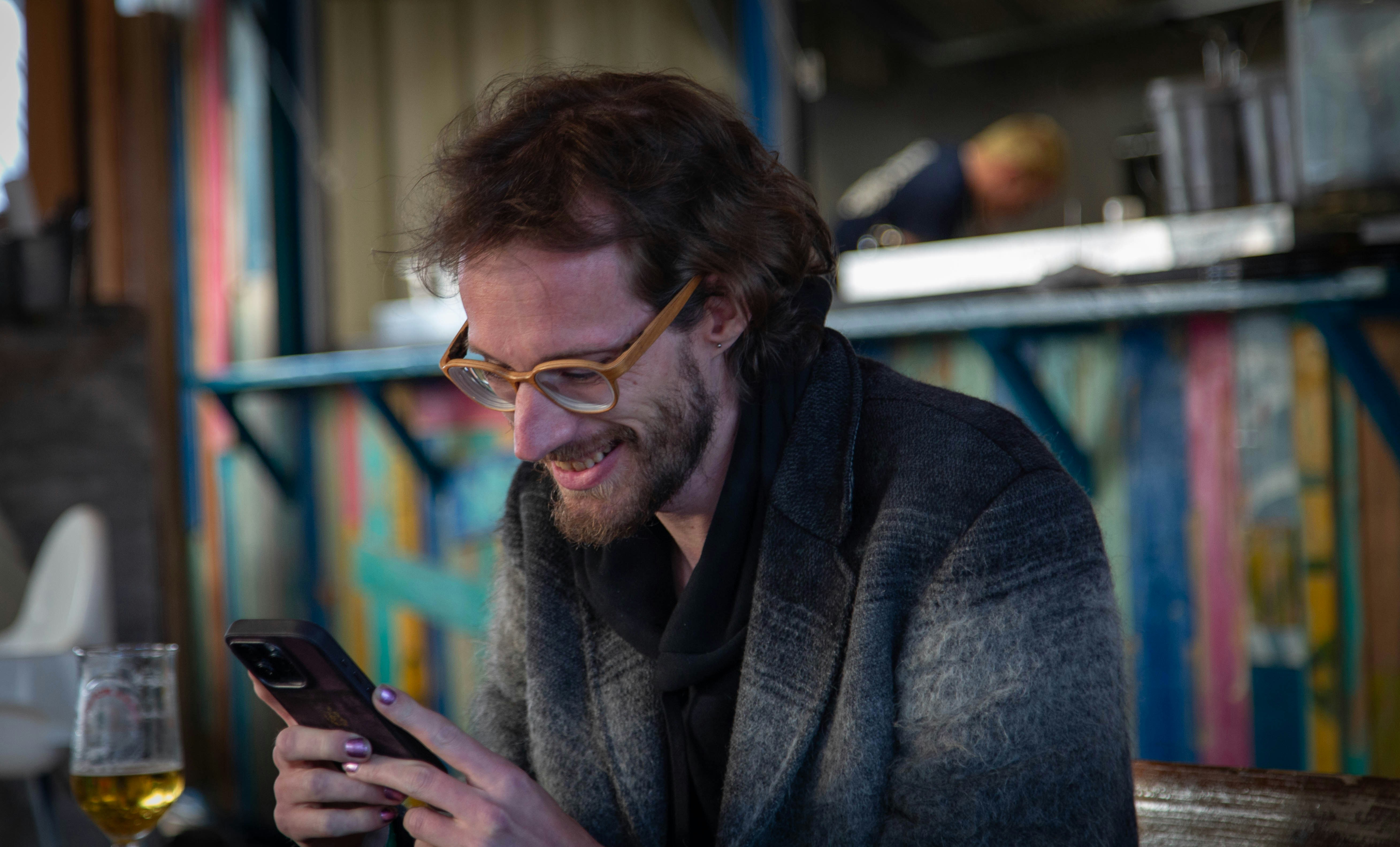 A man sitting at a table looking at a cell phone