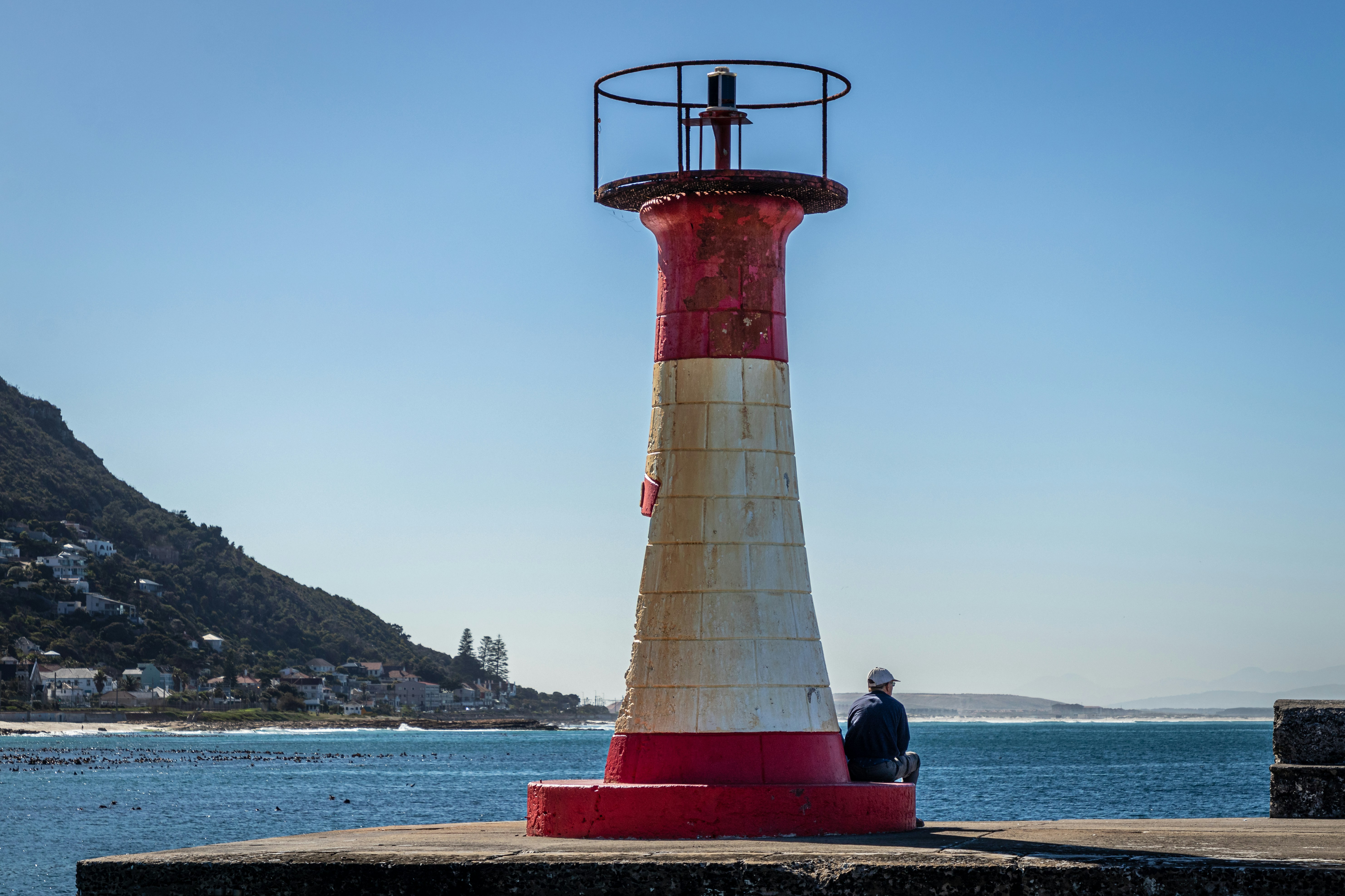 A red and white lighthouse sitting on top of a pier