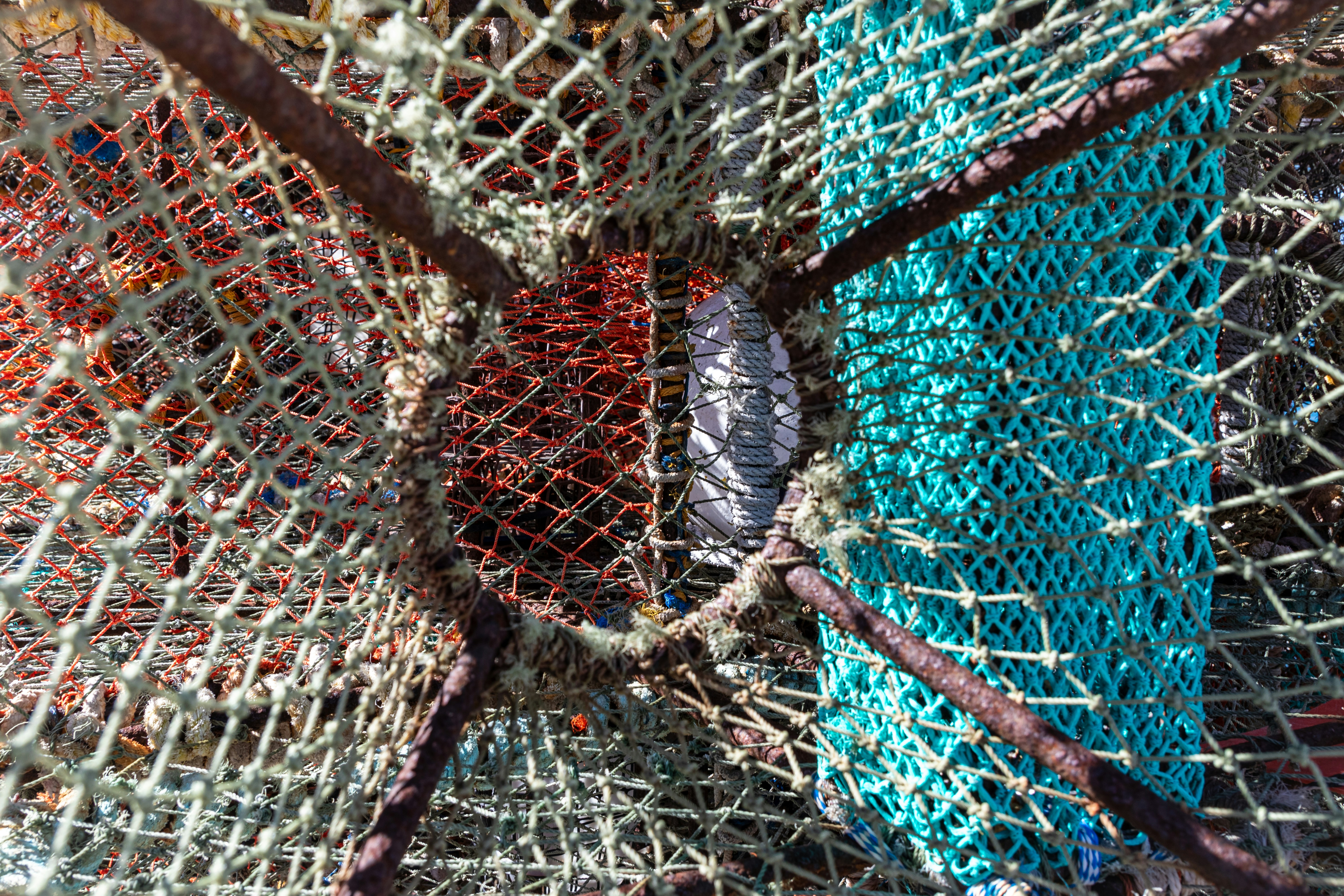 A pile of colorful fishing nets sitting on top of a beach