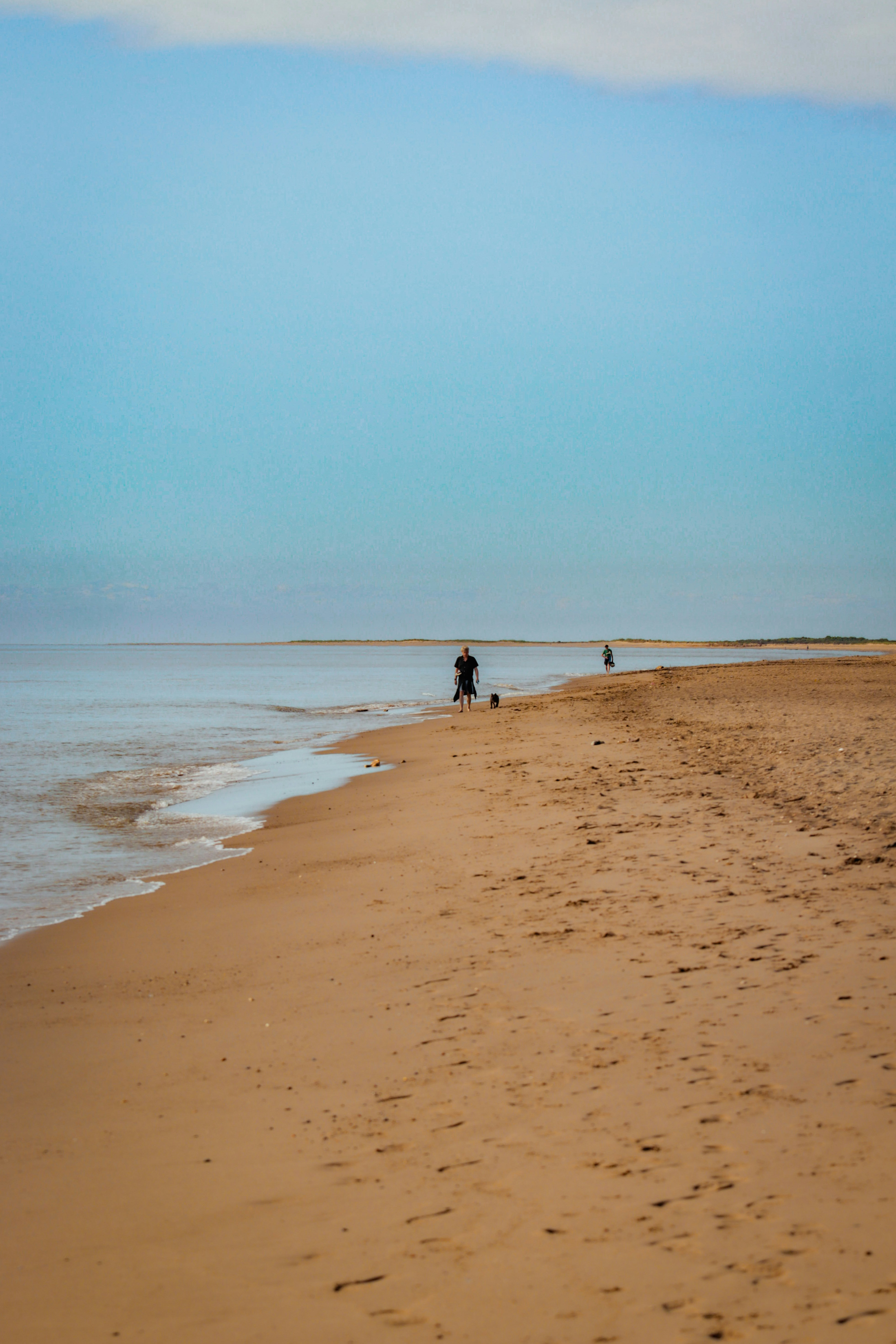 Una persona caminando por una playa junto al océano