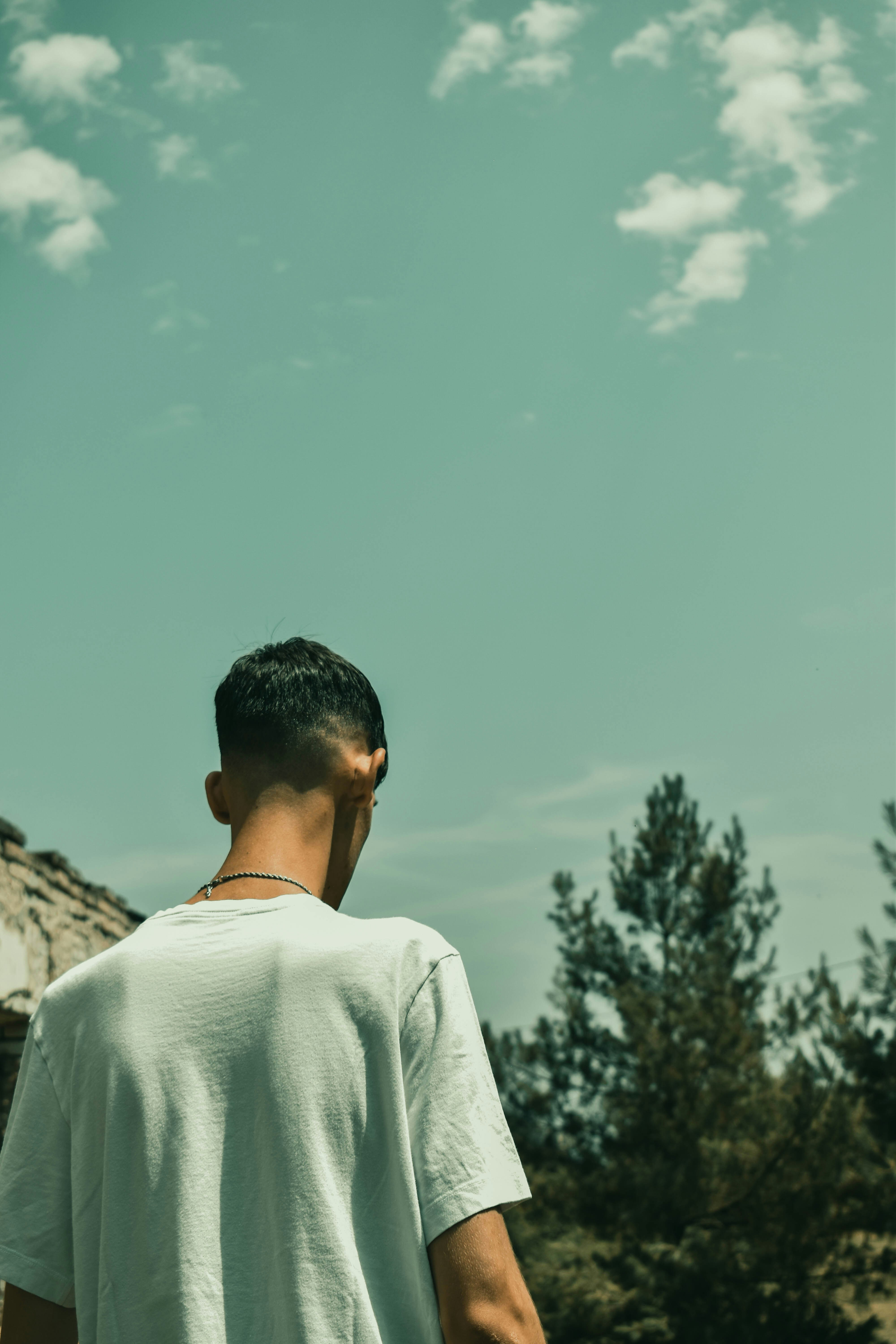 A man in a white shirt is flying a kite