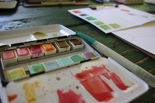 A close up of a palette of watercolors on a table