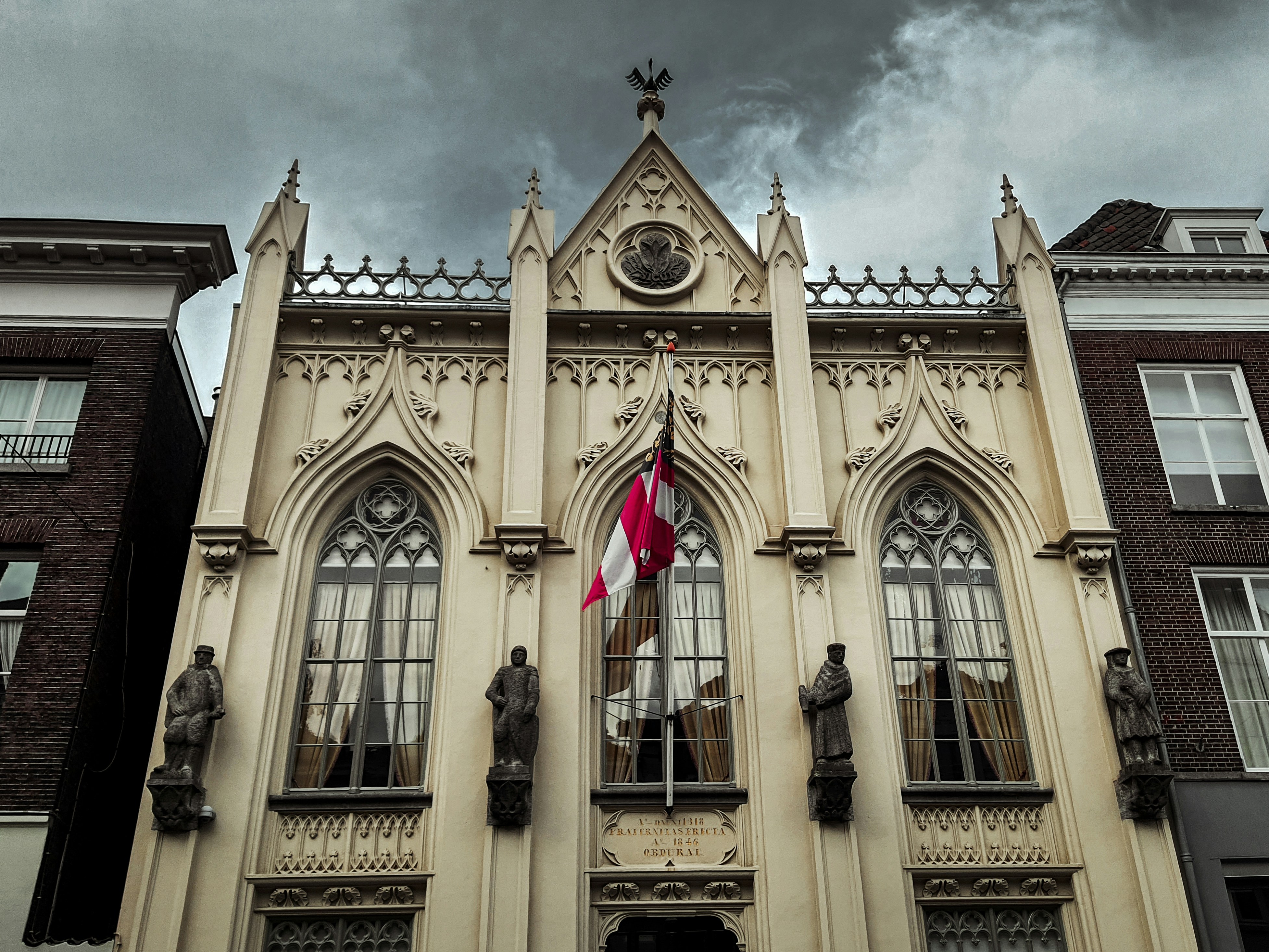 Aannemer Den Bosch — A tall building with a flag on top of it — Aannemer in 's-Hertogenbosch: kosten, vergunning en lok