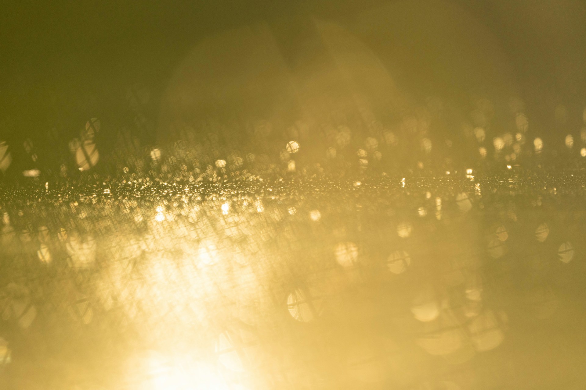 A blurry photo of the sun shining through the rain