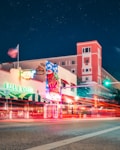 A city street at night with a building in the background