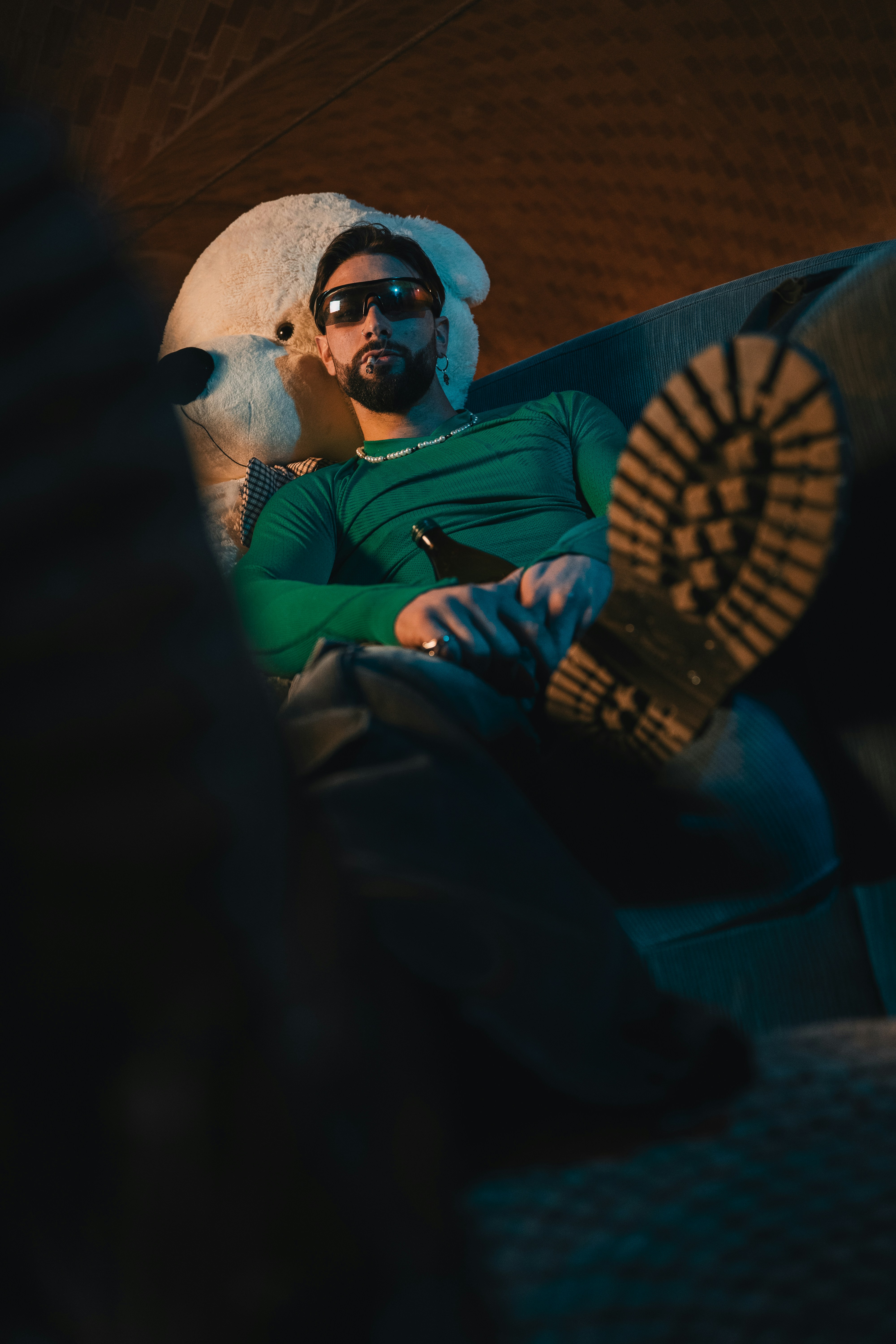 Un hombre sentado encima de un sofá junto a un perro