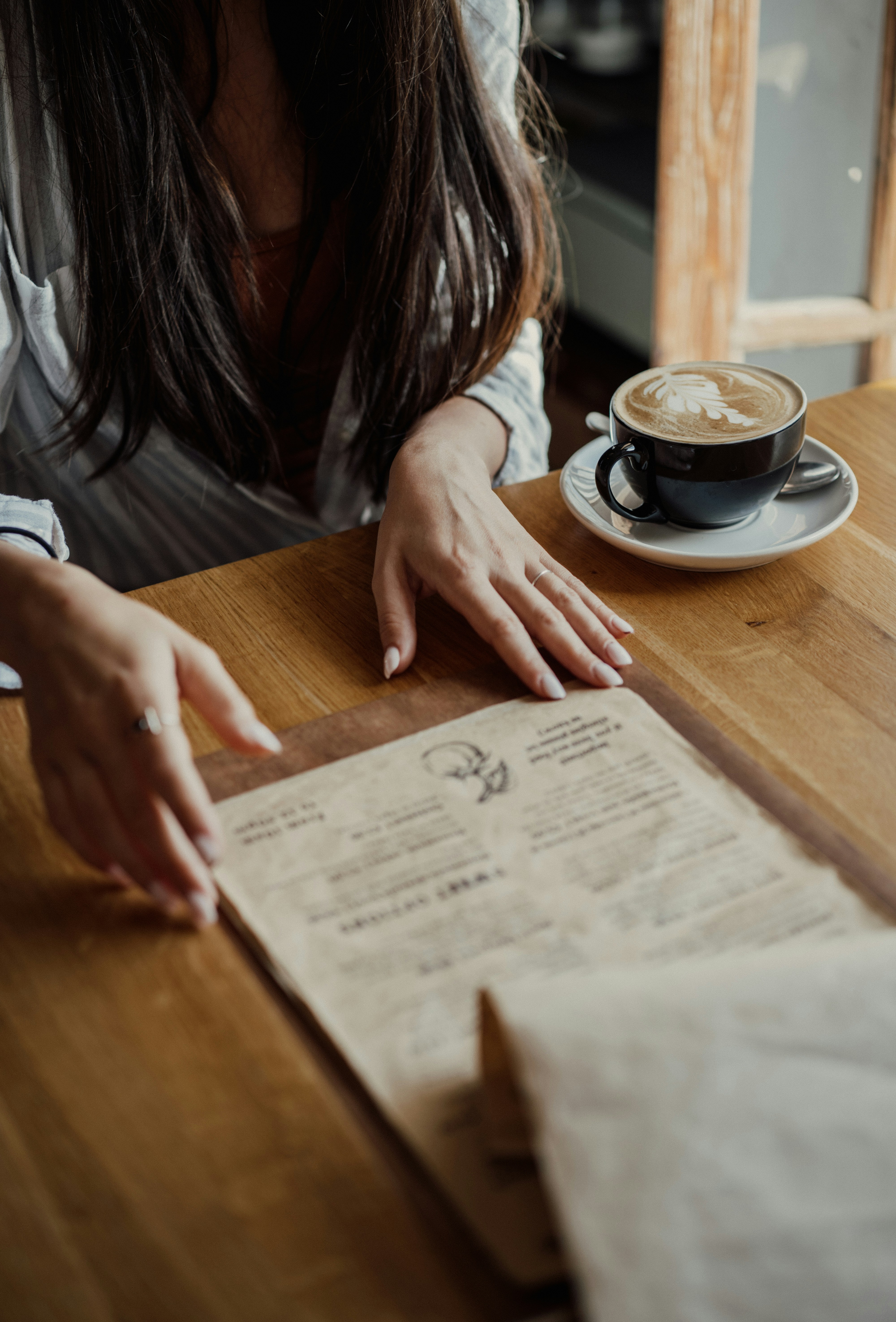 A woman sitting at a table with a menu in front of her