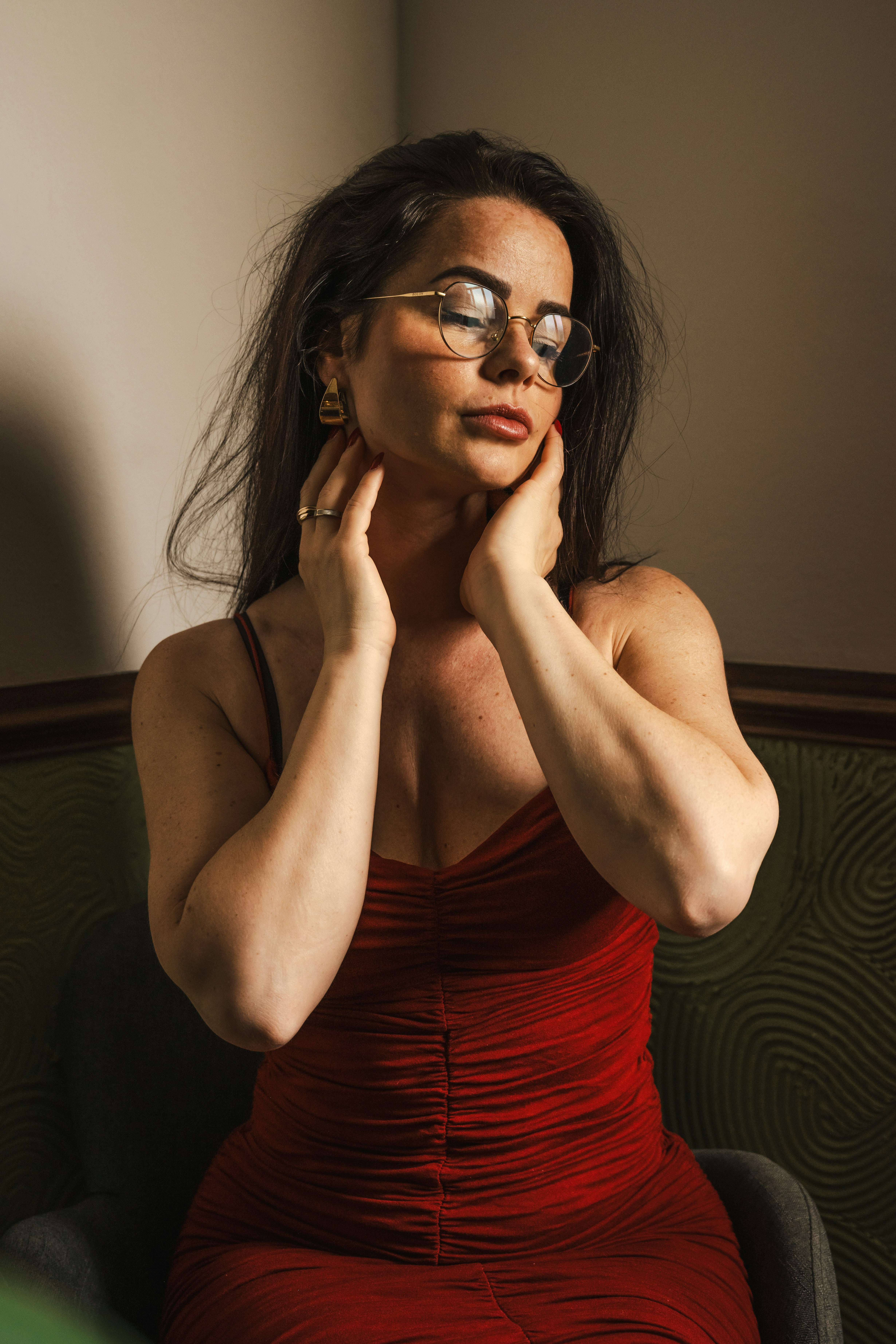 A woman in a red dress sitting on a green chair
