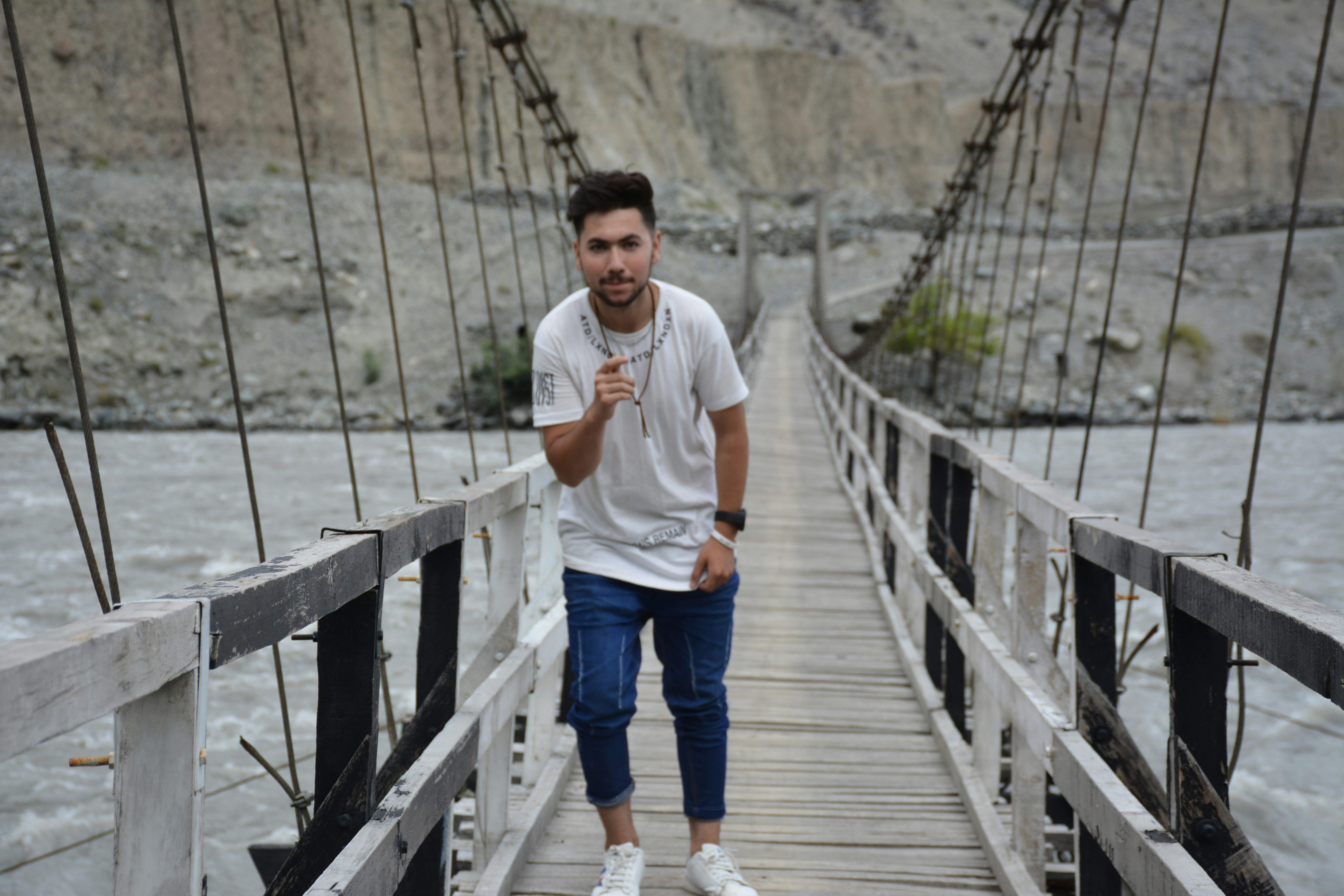 A man standing on a bridge over a river