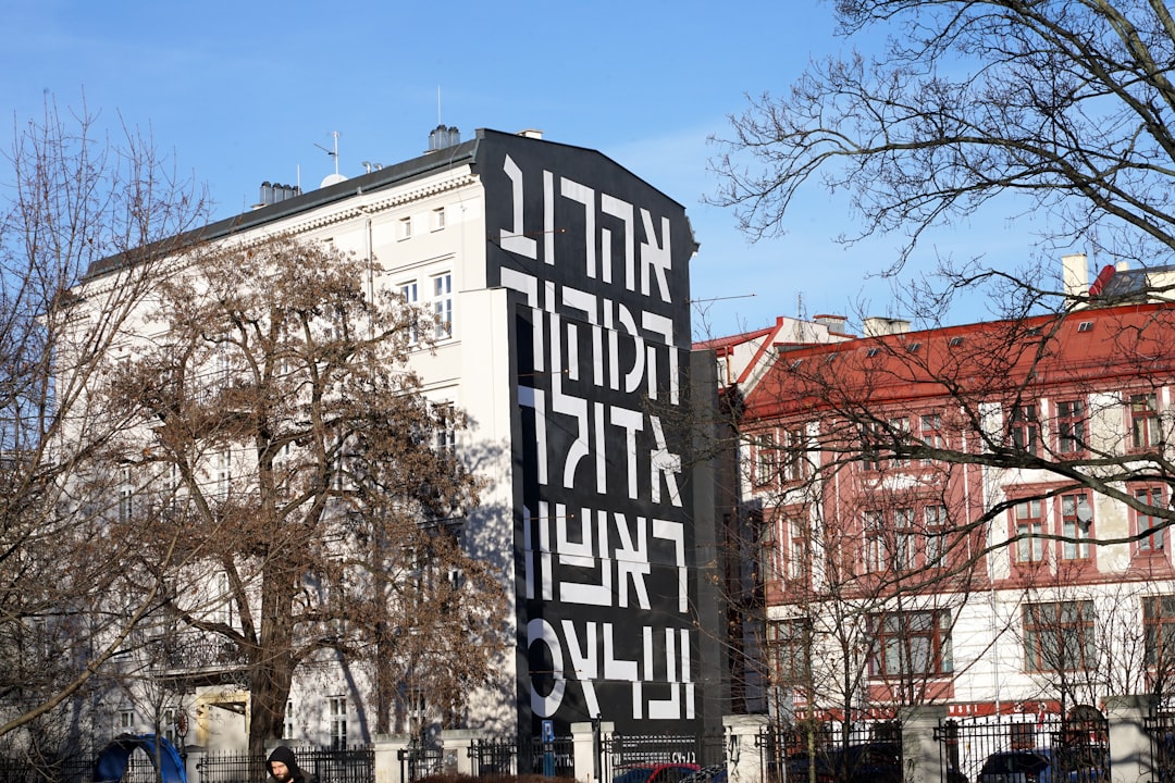 A large sign in front of a tall building, A message in Hebrew on a building in Wroclaw... (Apparently it means ניקוי . ניקוי . ניקוי -
