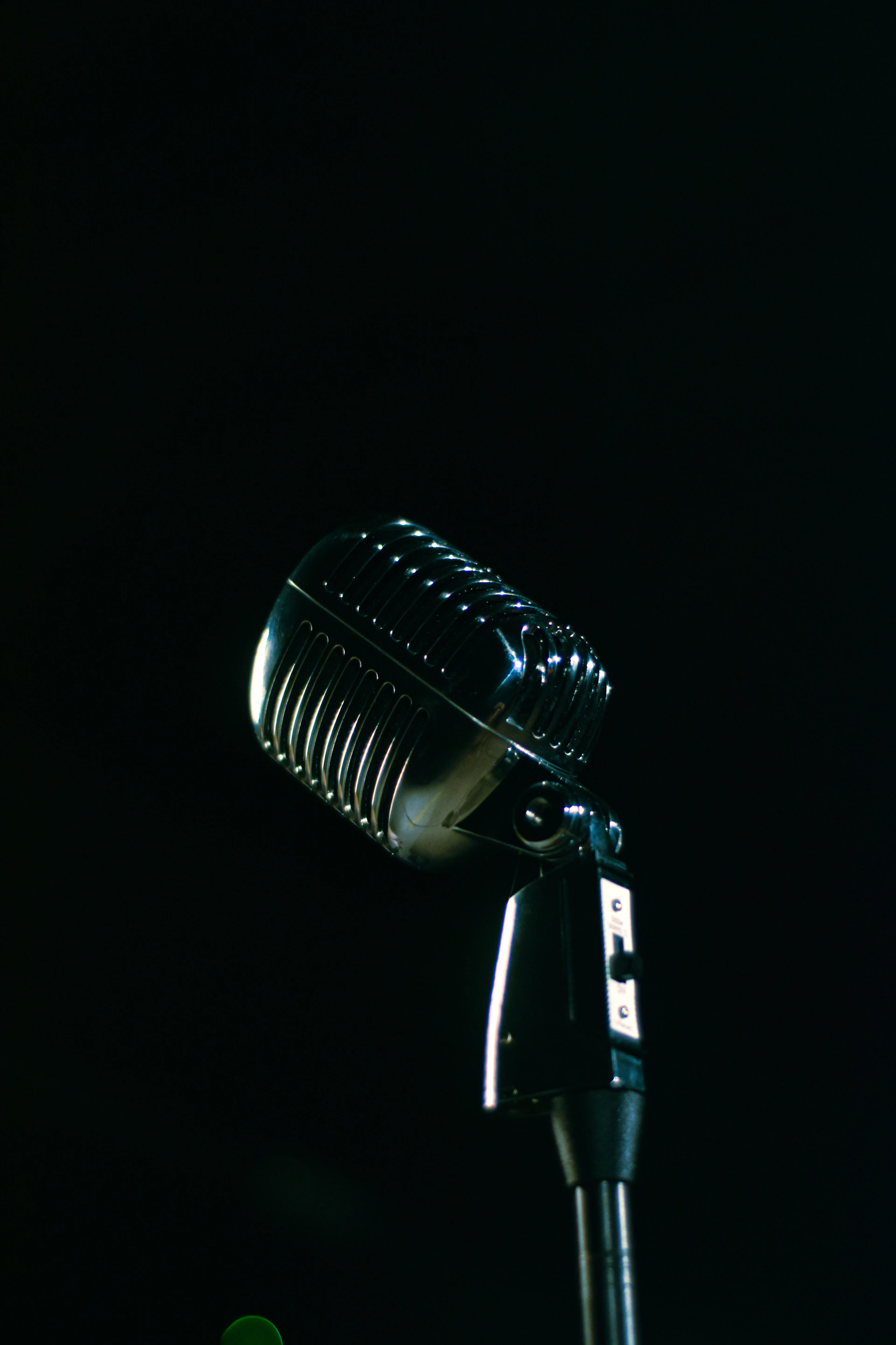 A microphone is shown in the dark with a blurry background