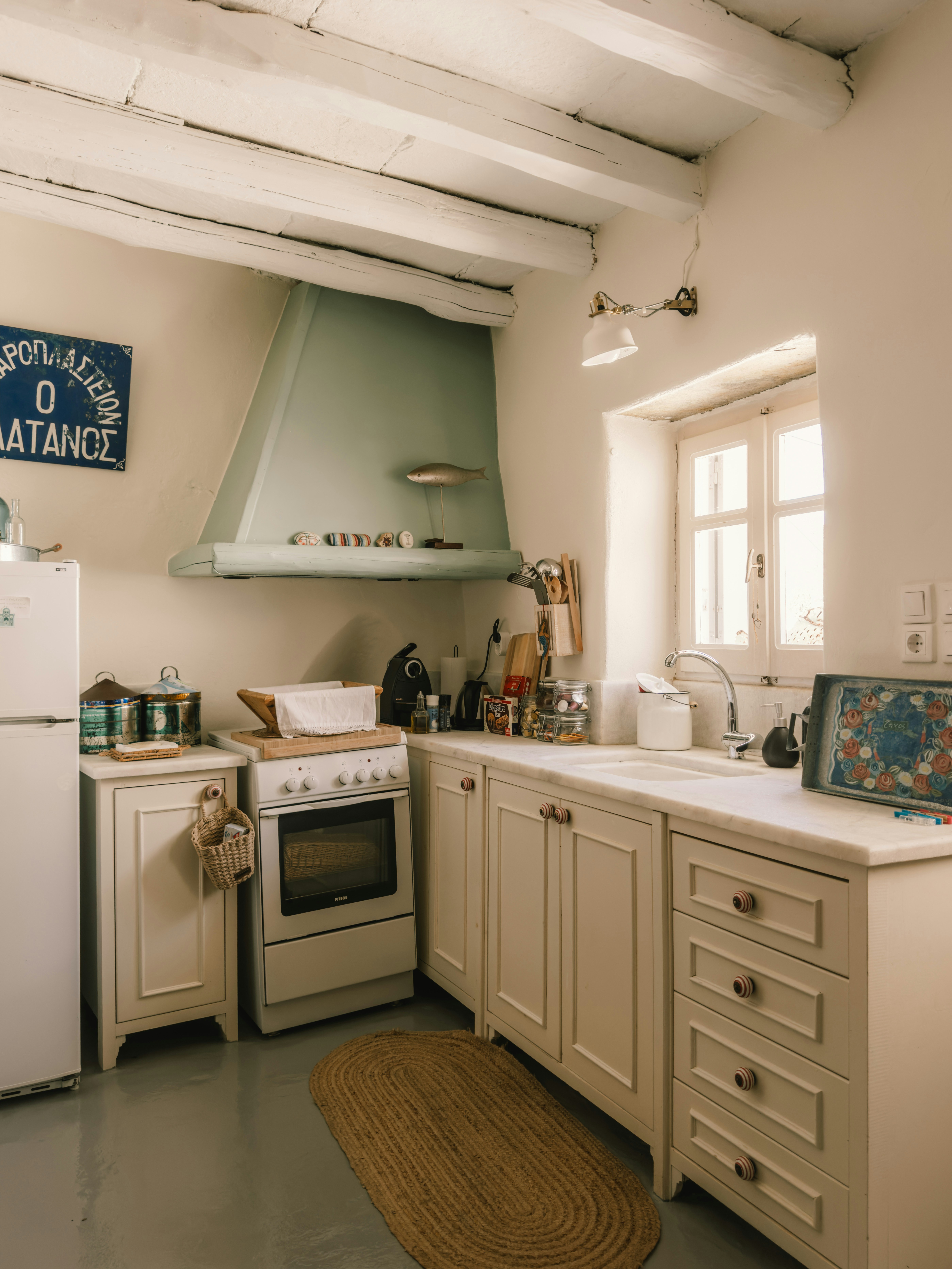 A kitchen with a stove, refrigerator, sink, and stove top oven