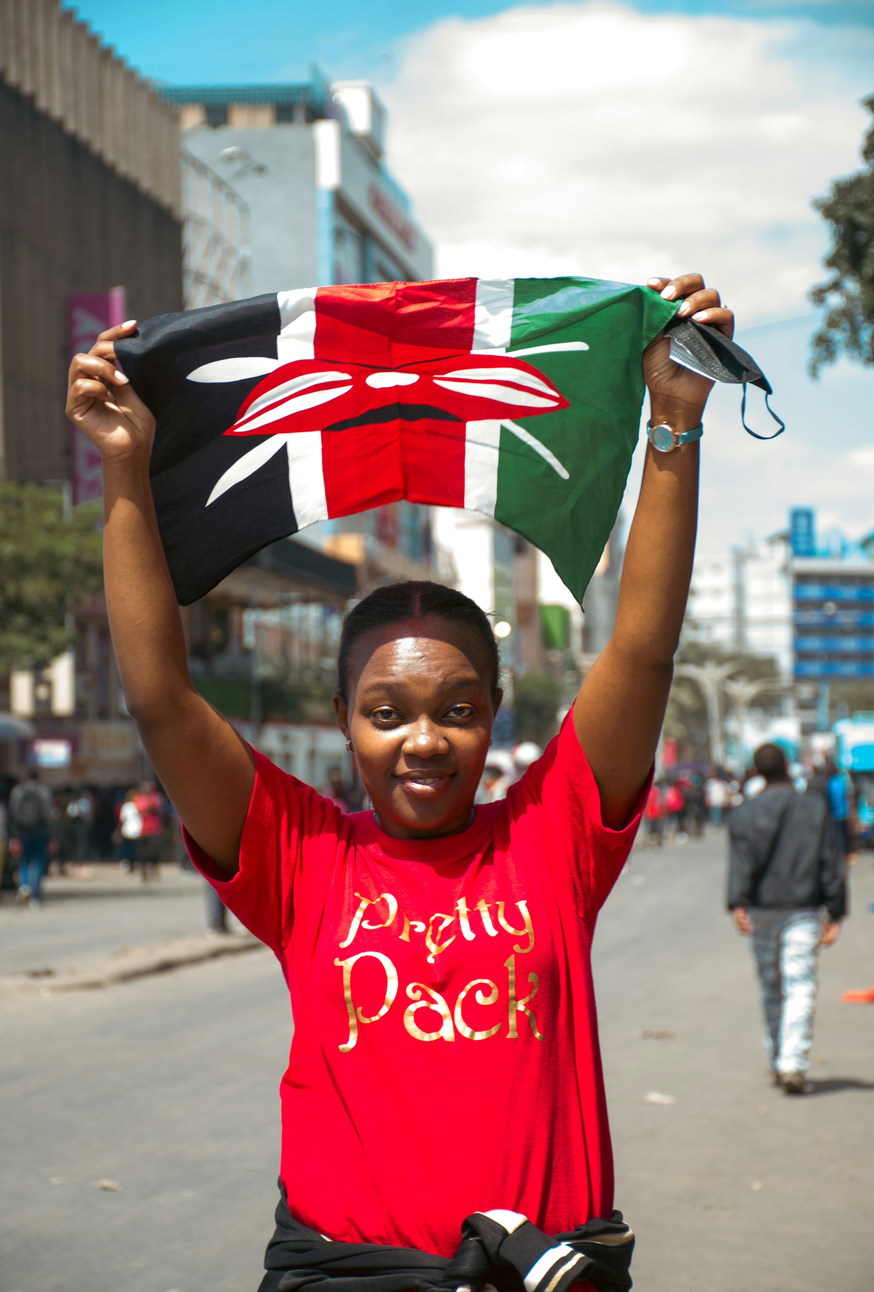 A woman in a red shirt is holding a flag