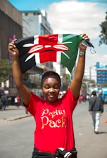 A woman in a red shirt is holding a flag