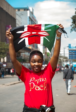 A woman in a red shirt is holding a flag