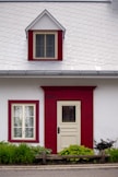 A white and red house with a red door