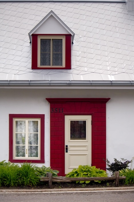 A white and red house with a red door