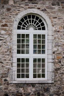 A stone building with a window and a clock
