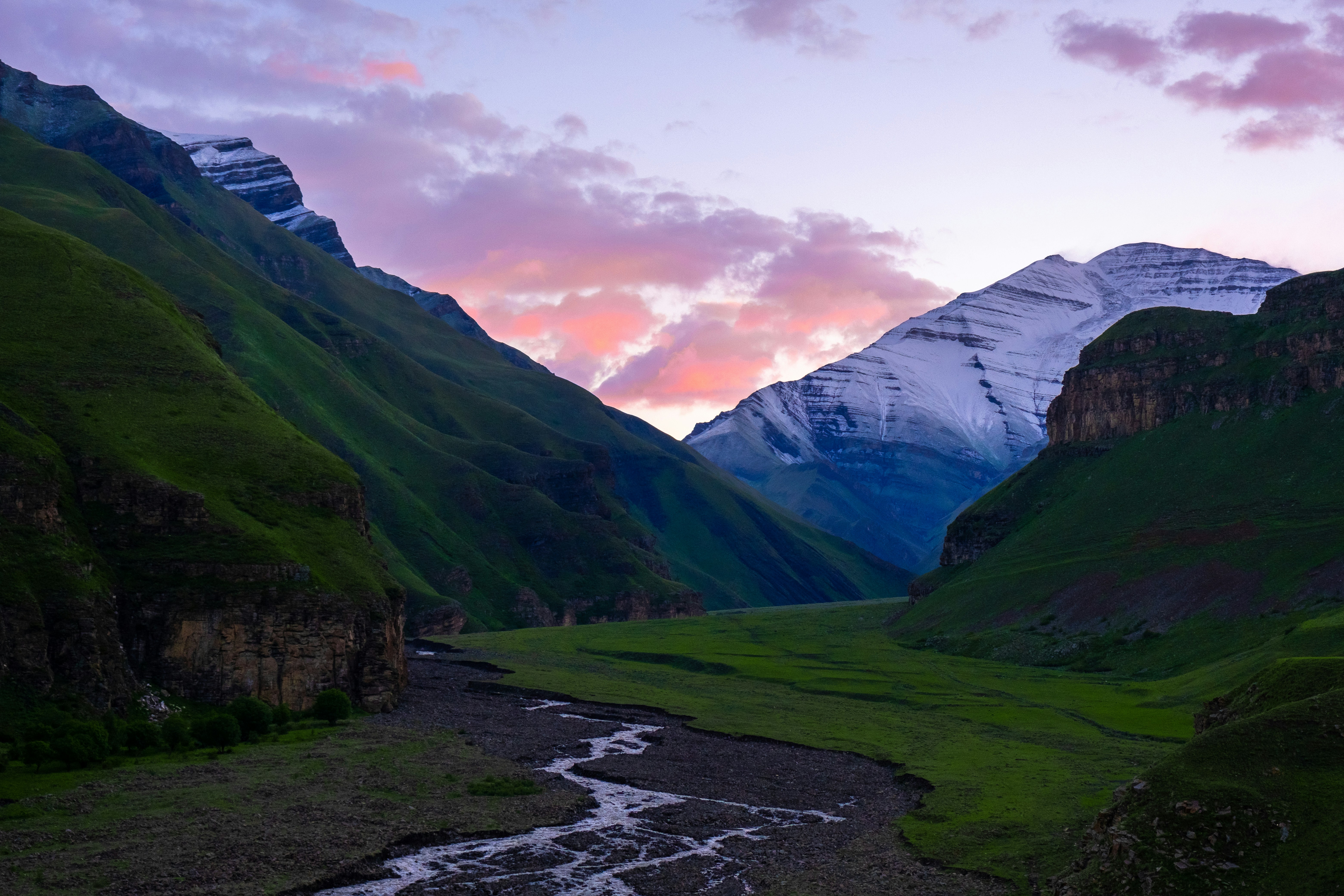 A river running through a lush green valley